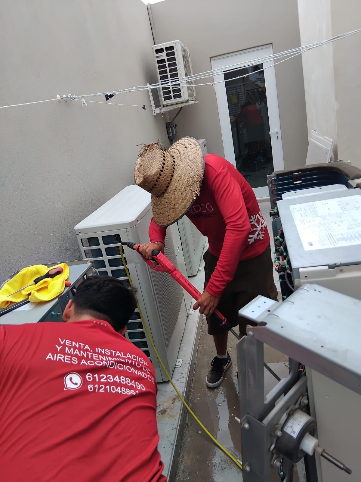 Técnicos de ALDICO lavando equipos de aire acondicionado